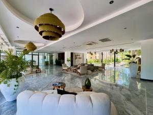 a living room with white furniture and a large lobby at Unwind | Private Balcony & Rooftop Pools | Casago in Tulum