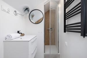 La salle de bains est pourvue d'une douche et d'un lavabo avec un miroir. dans l'établissement Komfortowe Studio z Klimatyzacja dla 2 osob w Gliwicach, à Gliwice