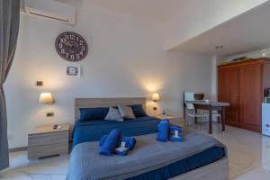 um quarto com uma cama azul e um relógio na parede em Gestione immobiliare Laura’s rooms em Roma