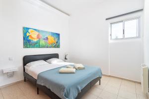 um quarto branco com uma cama com toalhas em BLife Vistaya private apartment em Faro