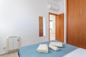 ein Schlafzimmer mit einem Bett mit Handtüchern darauf in der Unterkunft BLife Vistaya private apartment in Faro
