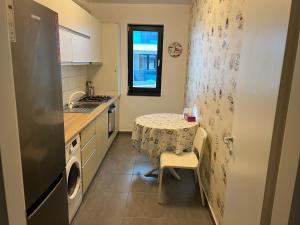 een kleine keuken met een tafel en een wastafel bij Garsoniera Genova in Otopeni