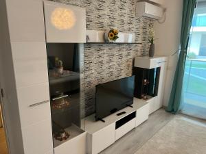 een woonkamer met een tv in een witte kast bij Garsoniera Genova in Otopeni