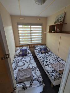 2 łóżka w małym pokoju z oknem w obiekcie Riviera Zator w Zatorze