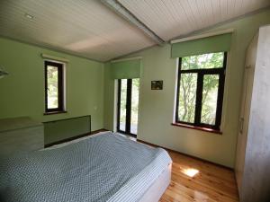 - une chambre avec un lit dans une pièce dotée de fenêtres dans l'établissement Istisu Valley Spa, à İsmayıllı