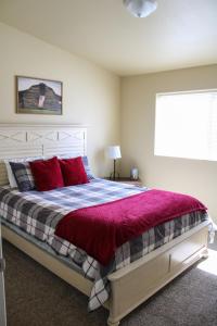 a bedroom with a large bed with red pillows at Chic Residence Near DT Sheridan in Sheridan