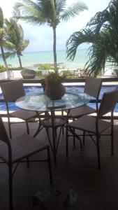 uma mesa e cadeiras com vista para a praia em Sereia do Mar Pousada Carapibus em Jacumã