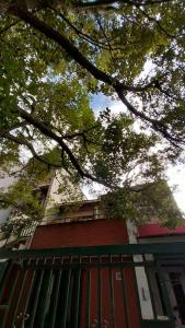 un edificio de ladrillo rojo con una valla verde en La casa del árbol en San Salvador de Jujuy