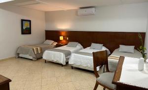 a hotel room with two beds and a table and chairs at Terrazas Vista Verde in Asunción