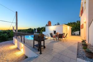 a patio with a table and chairs and a pool at Charmantes Apartment im Grünen mit Pool in Labin