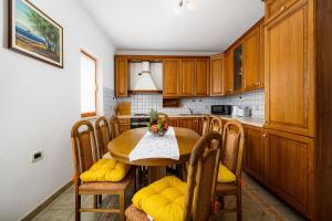 a kitchen with a table and chairs in a kitchen at Charmantes Apartment im Grünen mit Pool in Labin