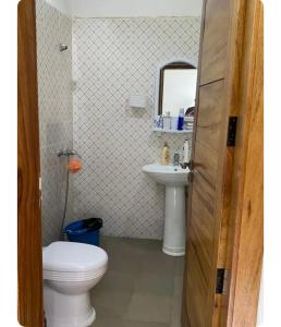 a bathroom with a toilet and a sink and a mirror at Charmante petite villa aux Mamelles in Ouakam