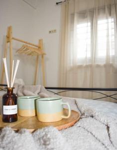 two coffee cups on a wooden tray on a bed at Filia's Countryside House in Chania Town