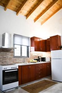 a kitchen with wooden cabinets and a white stove top oven at Filia's Countryside House in Chania Town