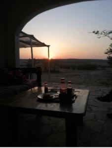 a table with drinks on it with the sunset in the background at Orwas maasai Mara safari camp in Kenya in Sekenani