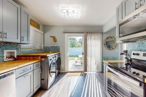 una cucina con armadietti bianchi e lavastoviglie di Bradmore Casita a Palm Coast