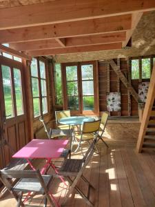 eine Terrasse mit einem Tisch und Stühlen in einer Hütte in der Unterkunft Tiny House et yourte sous les Poiriers in Domfront
