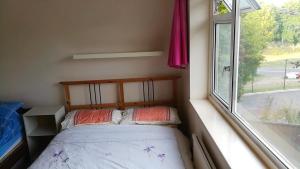 a small bed in a small room with a window at 15 mins from East Croydon to Central London, Gatwick - Sleeps up to 4 plus Cot - Free WiFi, Parking - Next to Lloyd Park, Great for Walkers - Ideal for Contractors - Families - Relocators in Croydon