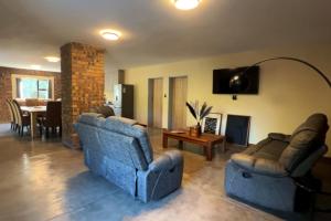 a living room with two blue couches and a table at Melamar Estate in Marloth Park