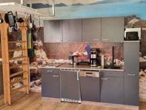 a kitchen with stainless steel appliances and a painting on the wall at 80 m2, für bis 6 Personen mit tollem Skigebiet, zentral und doch ruhig in Waidring