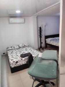 a small room with a bed and a table in it at Encantadora Casa, Ubicación Ideal en Bucaramanga in Bucaramanga