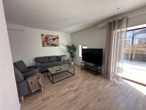 a living room with a couch and a television at Lägenheter Vallersgatan in Visby
