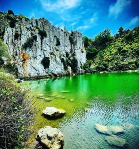 zielone jezioro ze skałami przed górą w obiekcie La maison du bonheur les eaux vives 1 w mieście Saint Pierre La Mer