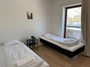 twee bedden in een kamer met een raam bij Lägenheter Vallersgatan in Visby