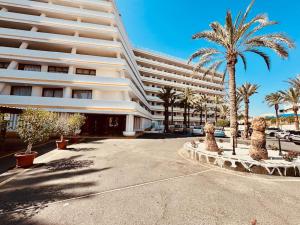 a large building with palm trees in front of it at Exclusive Holiday - Edifico Paraiso Maspalomas in San Fernando
