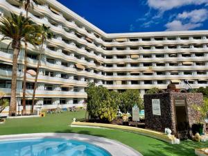a large building with a swimming pool in front of it at Exclusive Holiday - Edifico Paraiso Maspalomas in San Fernando