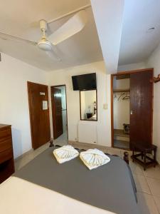a bedroom with two beds and a flat screen tv at Hotel Garay in San Bernardo