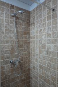 a shower in a bathroom with brown tiled walls at Apartamento Casa Dalí in Jerez de la Frontera