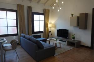 a living room with a blue couch and a tv at Apartamento Casa Dalí in Jerez de la Frontera