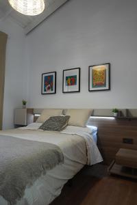 a bedroom with a bed with four pictures on the wall at Apartamento Casa Dalí in Jerez de la Frontera