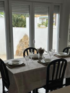 a dining room table with a white table cloth and chairs at Pinos del Mar in Huelva