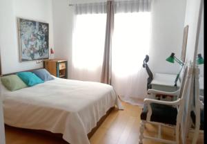 ein Schlafzimmer mit einem Bett, einem Stuhl und einem Fenster in der Unterkunft Cap Negret Altea in Altea