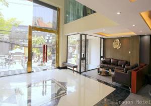 uma sala de estar com um sofá e uma grande janela em Golden Dragon Hotel Sài Gòn em Cidade de Ho Chi Minh