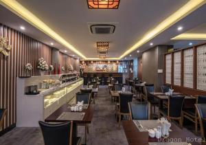 胡志明市的住宿－Golden Dragon Hotel Sài Gòn，一间带桌椅的餐厅和一间酒吧