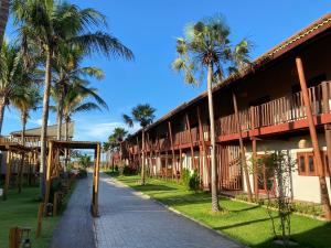 un edificio con palmeras junto a una acera en Pousada Encantos do Coqueiro en Luis Correia