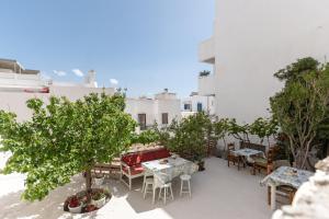 a patio with tables and chairs and trees on a building at Amaranto Naxos in Naxos Chora