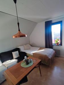 Habitación con cama, sofá y mesa. en Villaidyll i Svanesund nära havet en Svanesund
