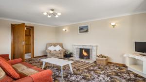 sala de estar con sofá y chimenea en Little Tara, Ballyconneely, en Ballyconneely