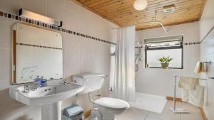 La salle de bains est pourvue d'un lavabo, de toilettes et d'un miroir. dans l'établissement Little Tara, Ballyconneely, à Ballyconneely