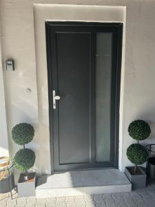 una puerta trasera negra de una casa con dos manías en Schöne Wohnung in Satrup en Satrup