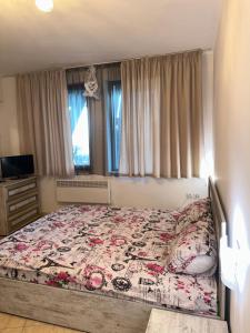 a bedroom with a bed with a quilt on it at Grand Monastery Pamporovo Luxury Apartment in Pamporovo