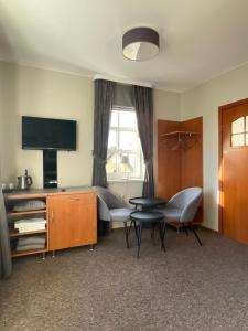 a hotel room with a bed and a tv at Pokoje Amber in Mikołajki