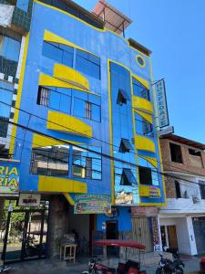 un bâtiment bleu et jaune avec des fenêtres jaunes dans l'établissement HOSPEDAJE Y TURISMO SOL & LUNA E.I.R.L, à Tarapoto