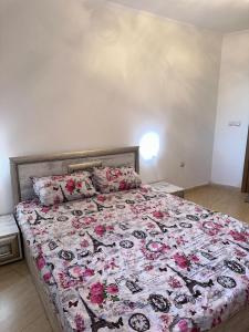 Un dormitorio con una cama grande con flores rosas. en Grand Monastery Pamporovo Luxury Apartment, en Pamporovo