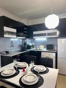 a kitchen with a table with plates and wine glasses at Grand Monastery Pamporovo Luxury Apartment in Pamporovo