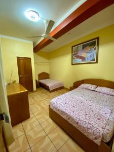 um quarto com 2 camas e uma ventoinha de tecto em HOSPEDAJE Y TURISMO SOL & LUNA E.I.R.L em Tarapoto